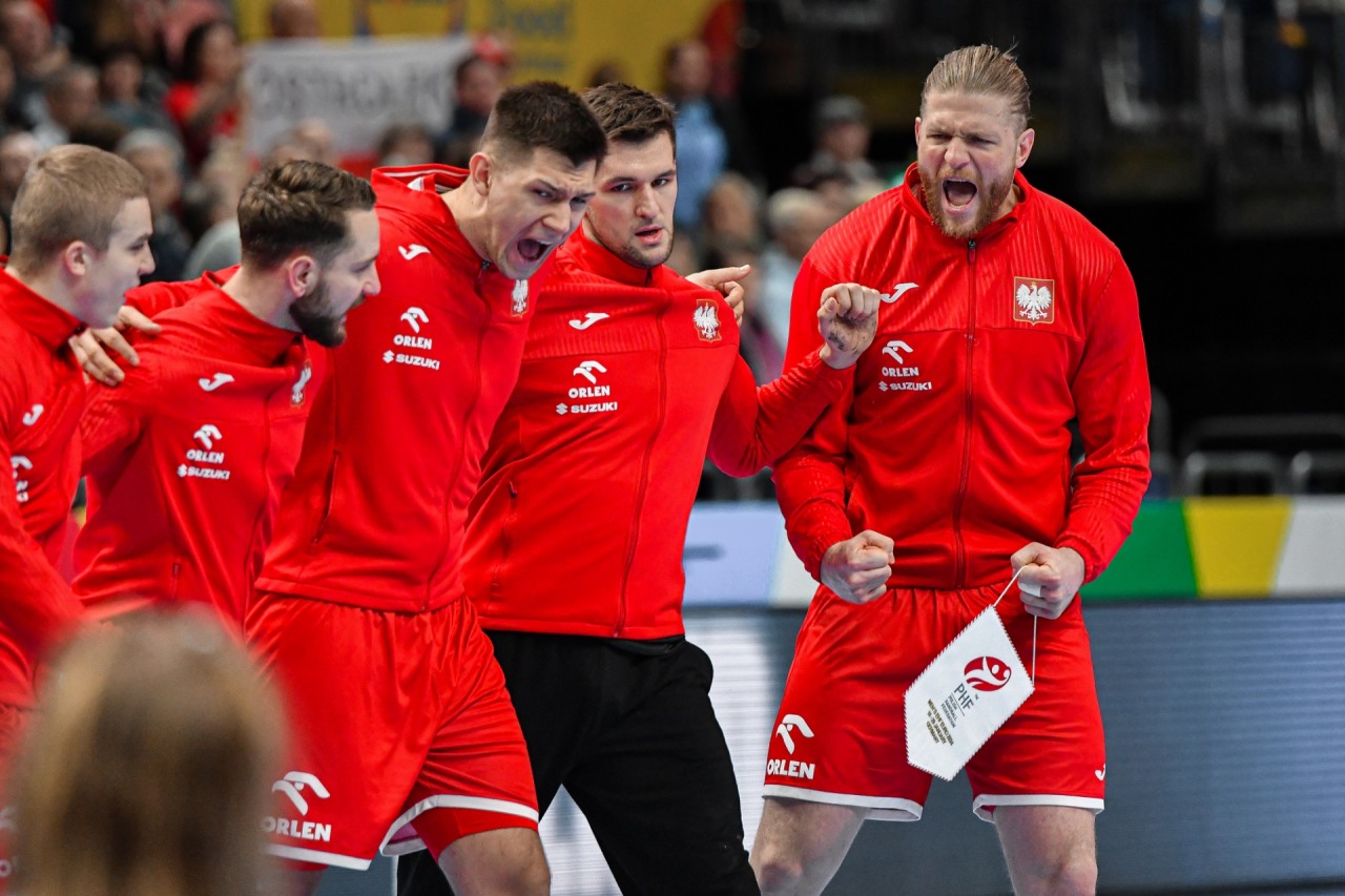 Zawodnicy podczas meczu piłki ręcznej ubrani w czerwone stroje z logo ORLEN.