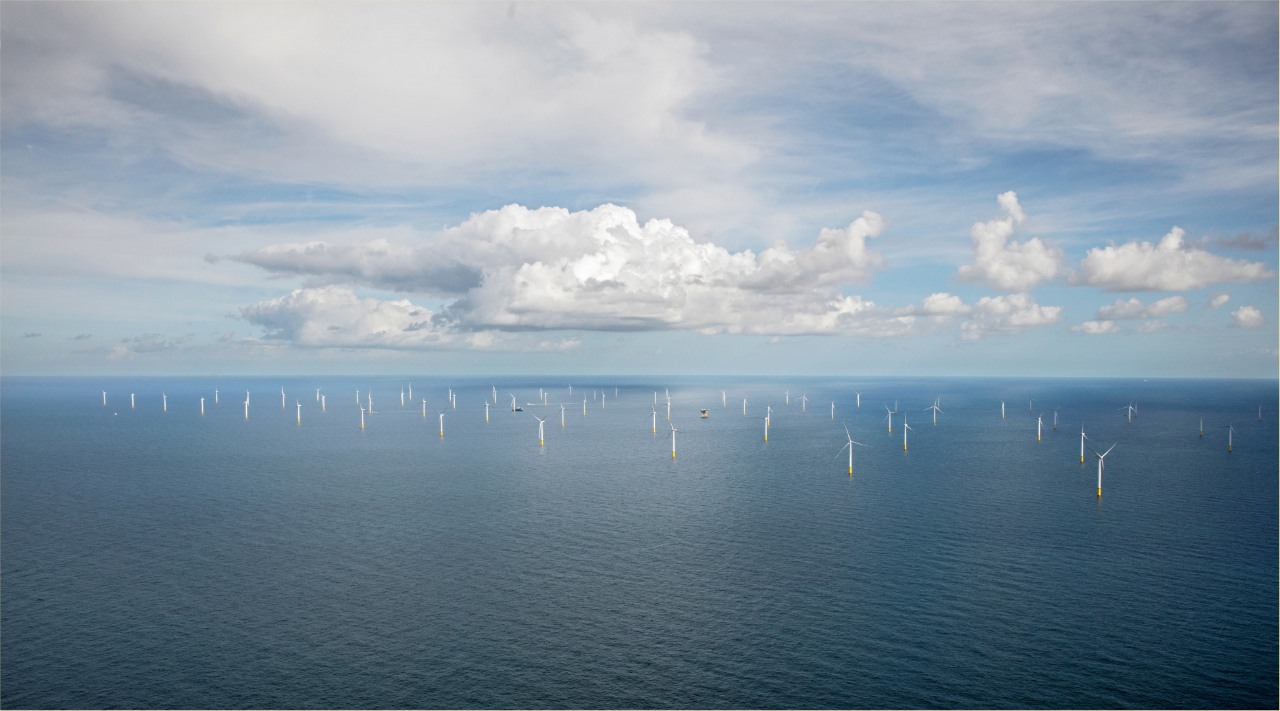 Energia odnawialna i OZE – grupa ORLEN. Białe turbiny wiatrowe rozmieszczone na morzu.