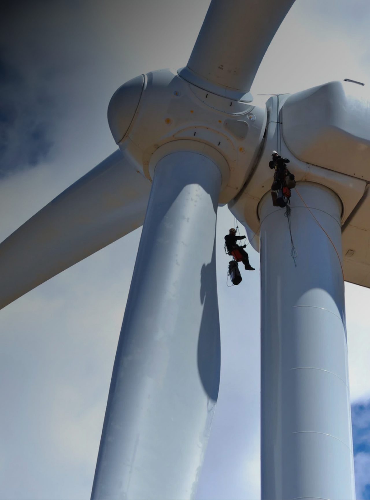 Workers on top of a wind farm fan