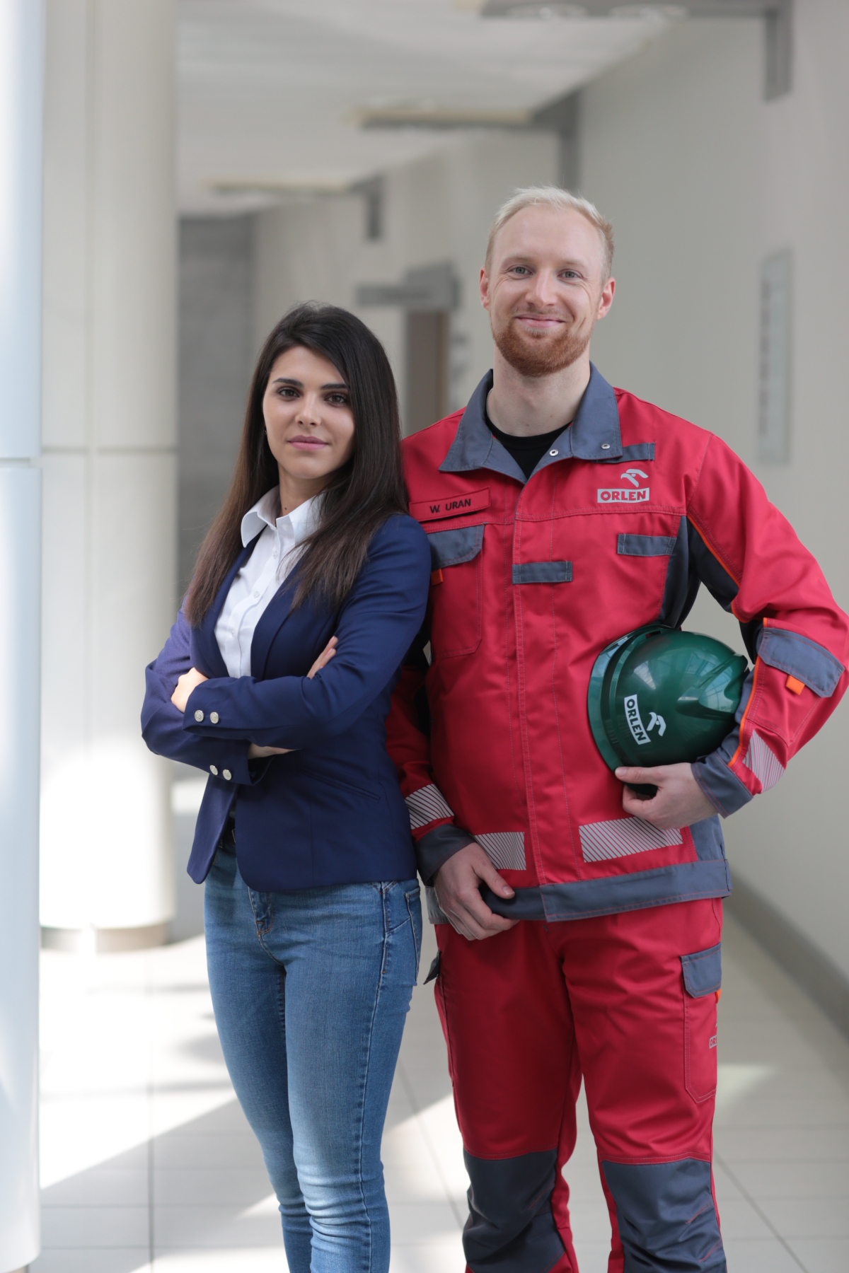 Two ORLEN Group employees, a woman in office attire and a man in a protective suit