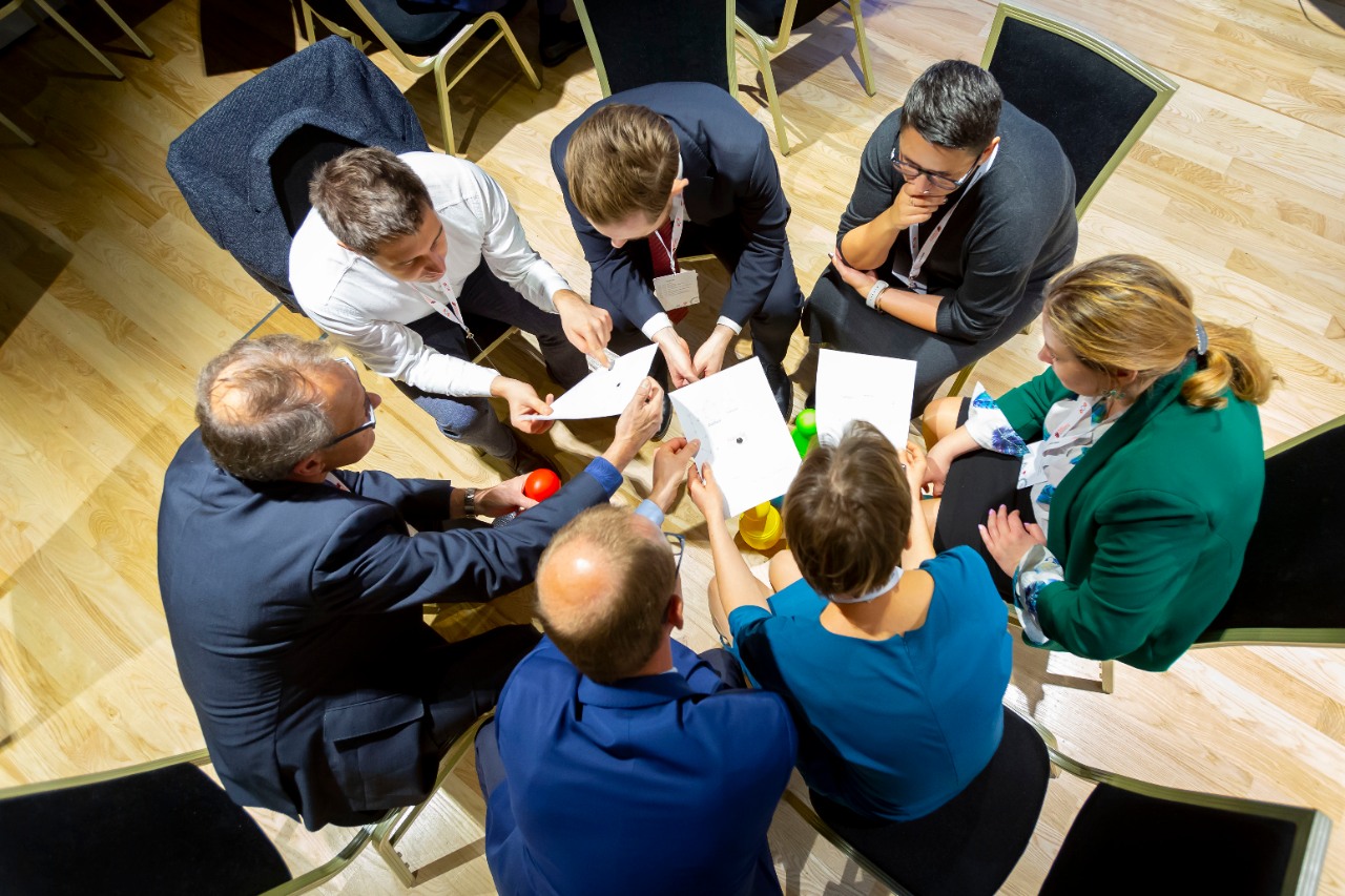 Group of people sitting around a table during a speech