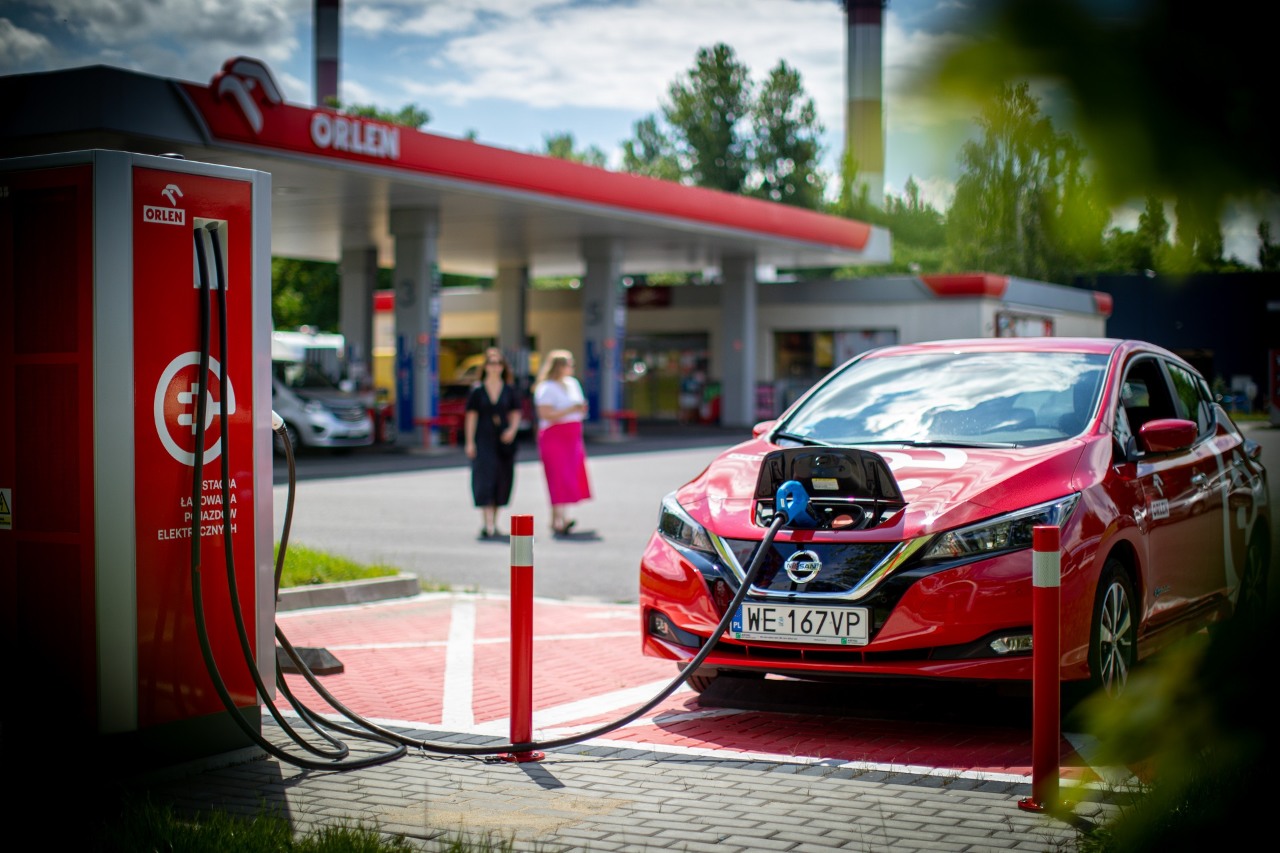 Samochód elektryczny podłączony do ładowarki na stacji pojazdów elektrycznych.