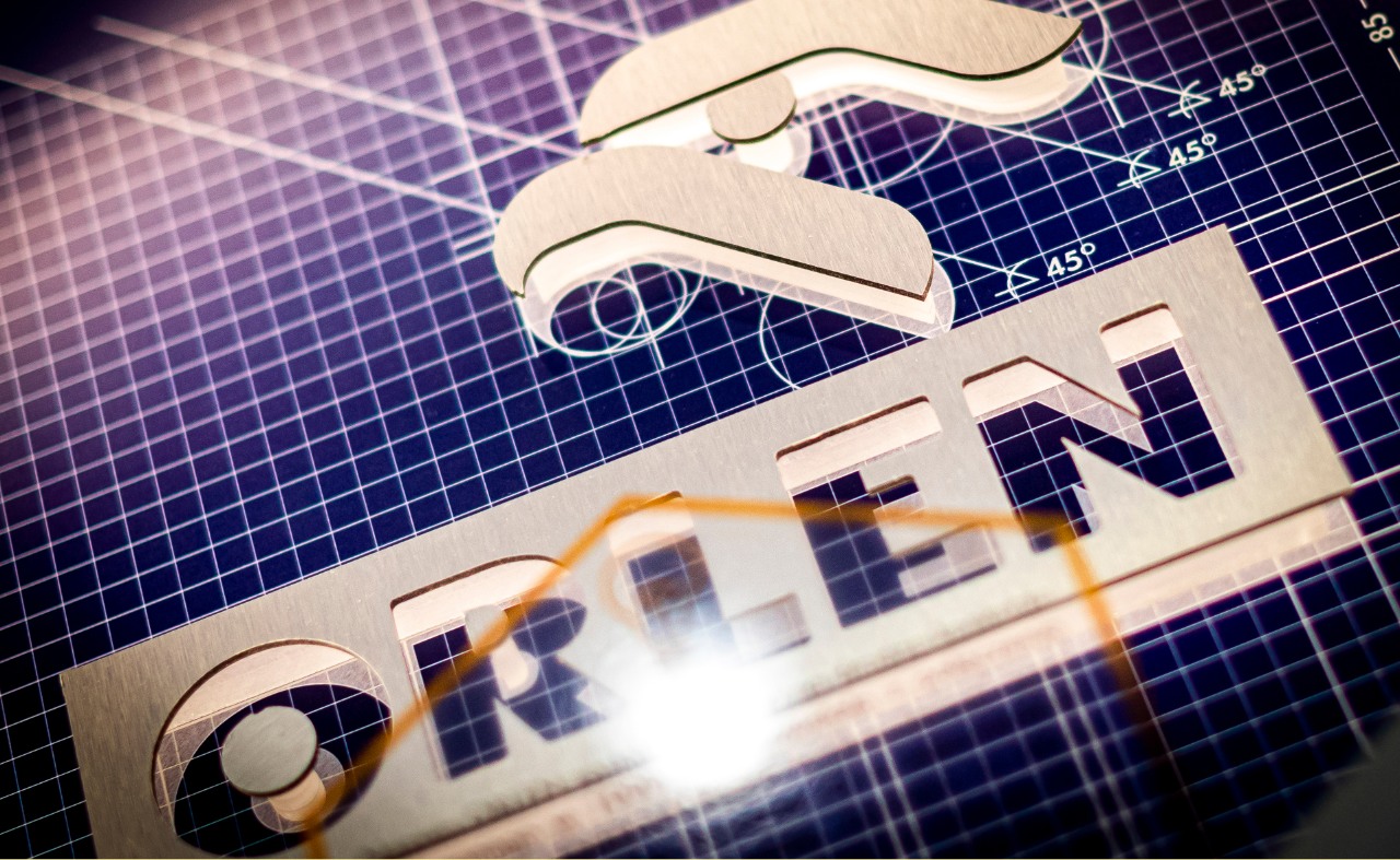 Golden ORLEN logo on a purple grid