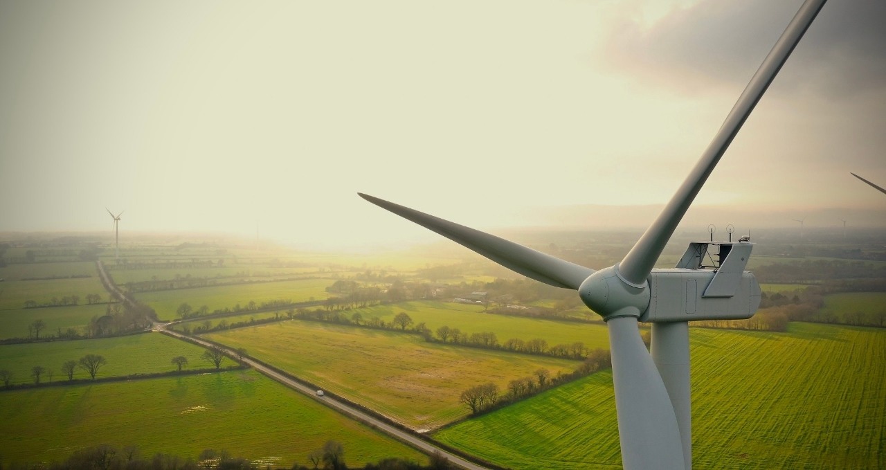 Wind turbine, farmland in the background