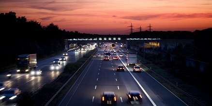 Stacje paliw ORLEN. Samochody poruszające się na drodze szybkiego ruchu nocą, z widocznymi światłami reflektorów,