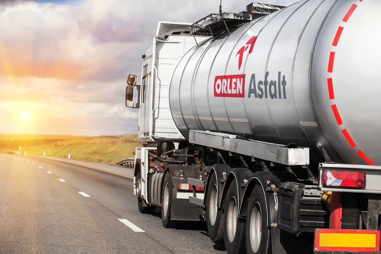 Inwestycje i innowacje – Grupa ORLEN. Cysterna z logo ORLEN Asfalt transportująca asfalt dla przemysłu budowanego i drogowego.
