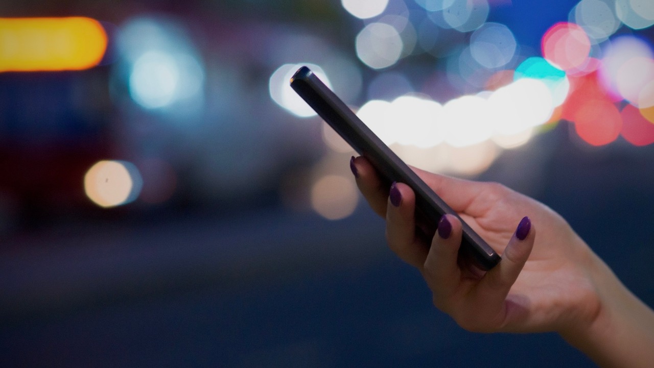 ORLEN aplikacje. Kobieta trzyma w dłoni telefon komórkowy.