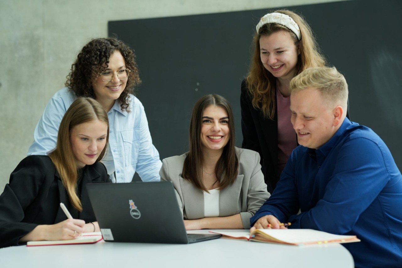 Grupa uśmiechniętych osób prezentuje statuetkę TOP Employer