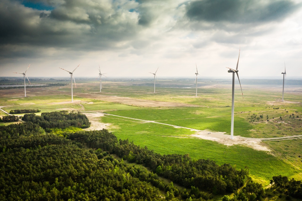 Odnawialne źródła energii - Grupa ORLEN i OZE. Wiatraki konwertujące siłę wiatru na odnawialną energię, przyczyniające się do zrównoważonej produkcji energii.