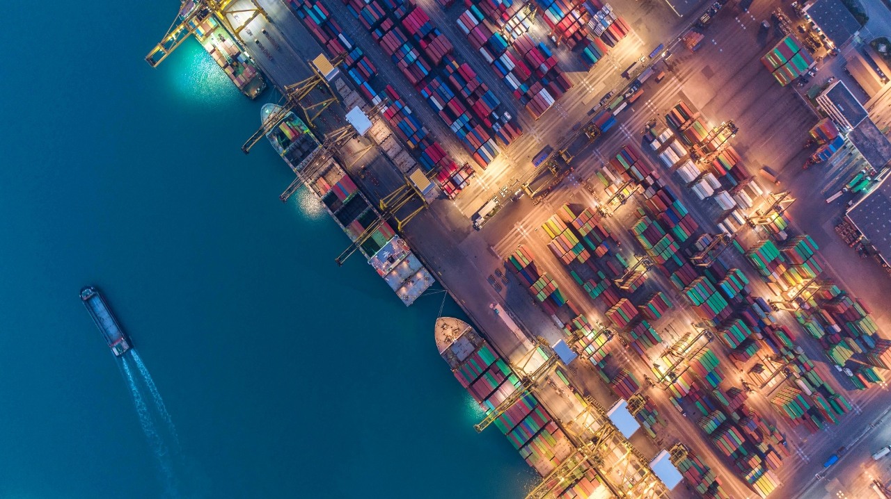 Container ship in export and import business and logistics. Shipping cargo to harbor by crane. Water transport International. Aerial view